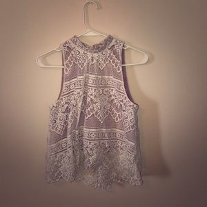 A laced shirt with a tan skin toned tank top.